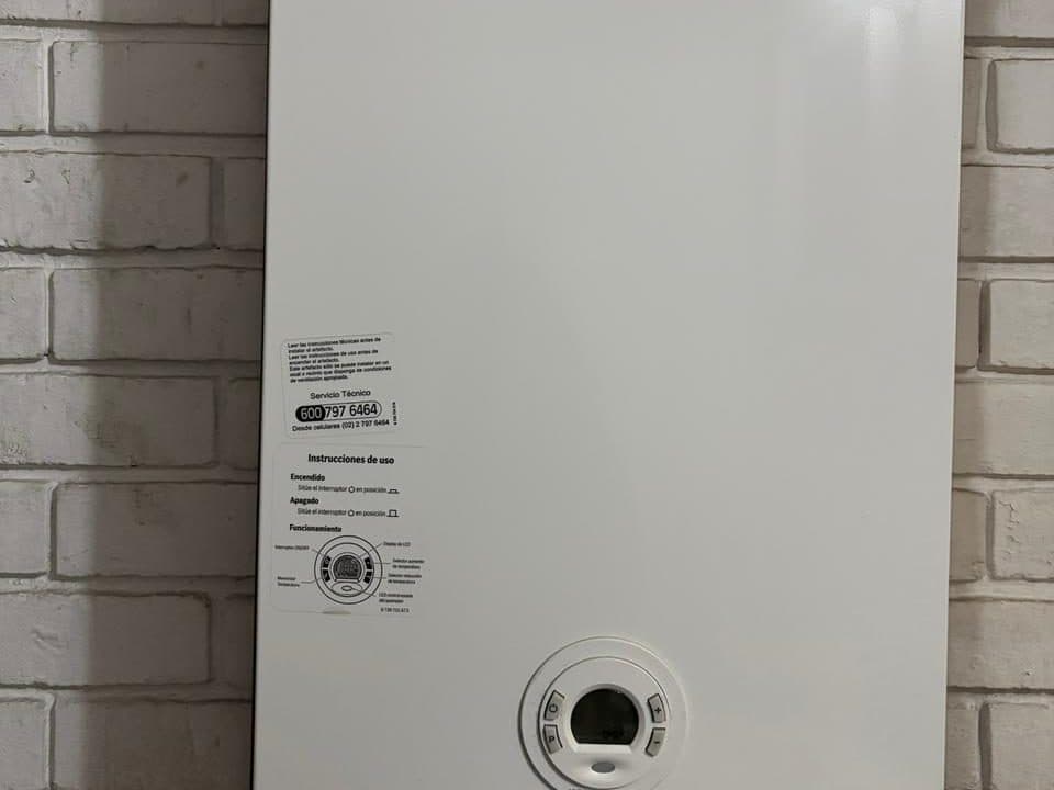 Calefont Junkers instalado sobre un muro de ladrillo pintado de blanco