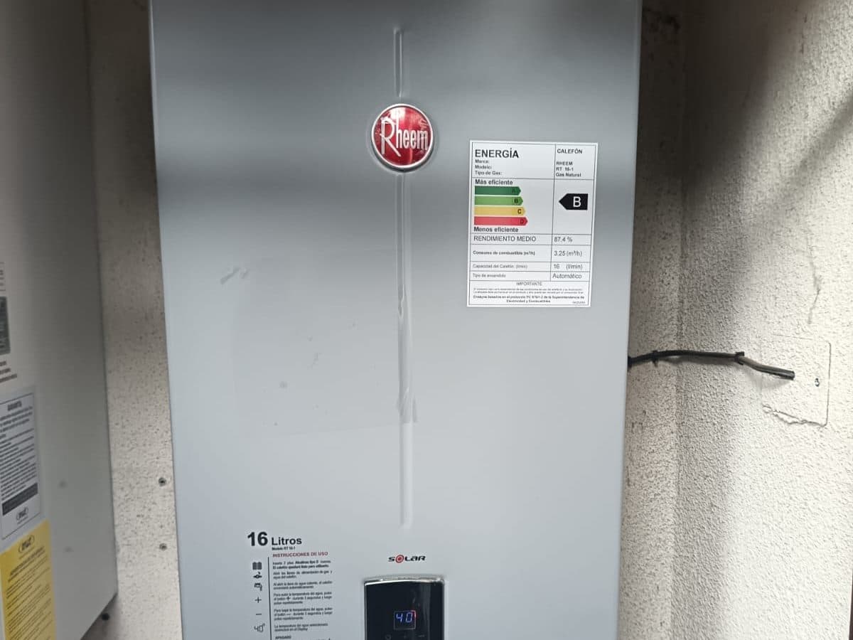 Calefont Rheem Solar de 16 litros instalado en un nicho del muro, con su etiqueta de eficiencia energética