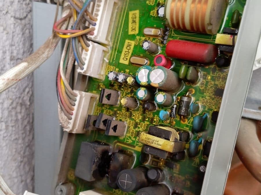 Placa electrónica de un calefont abierta para reparación, con sus componentes a la vista