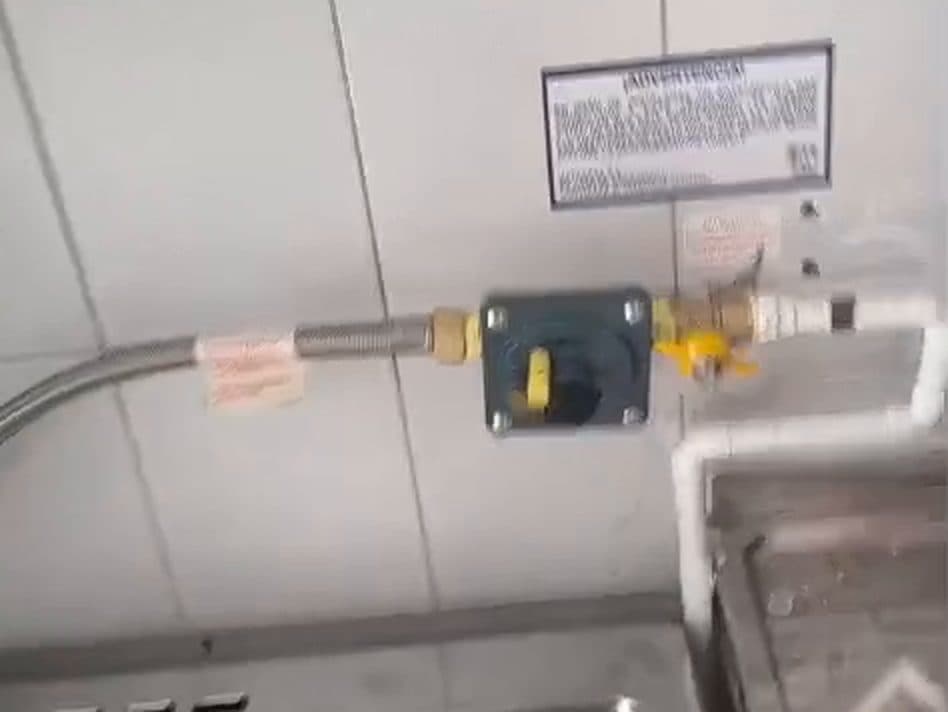Llave de paso amarilla y regulador en el muro de la cocina, conectados al flexible metálico nuevo