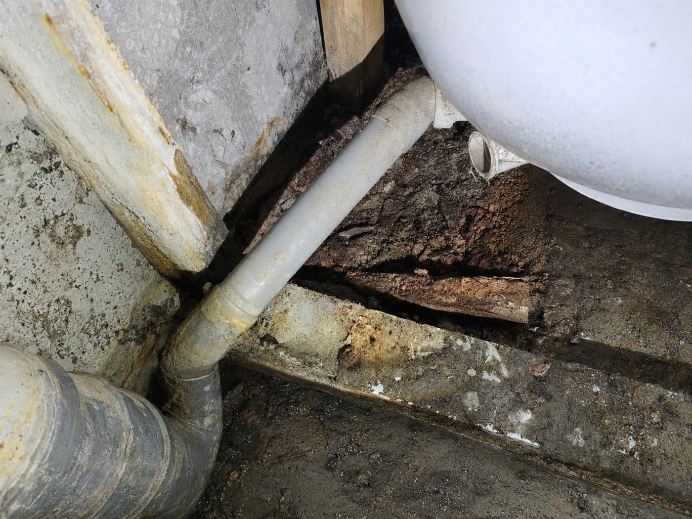 Cañerías corroídas y humedad por filtración bajo un artefacto sanitario en Las Condes