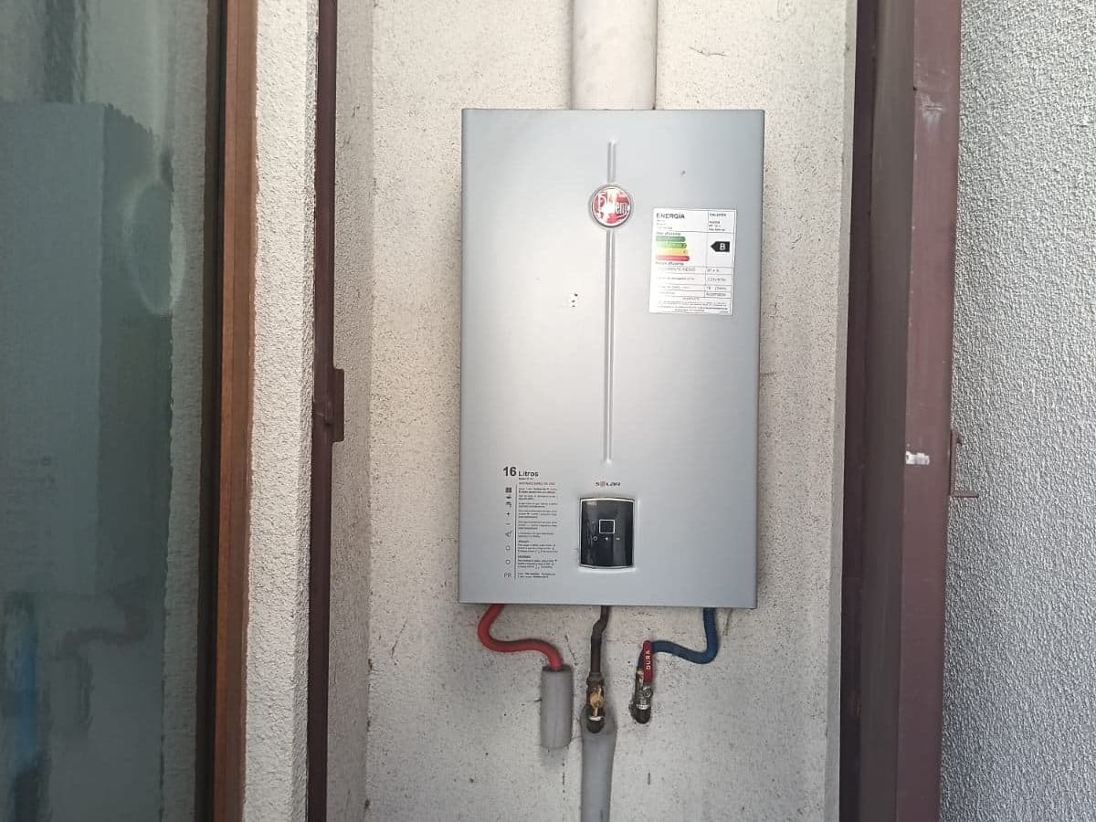 Calefont instalado en un patio de luz estrecho, con sus cañerías de cobre